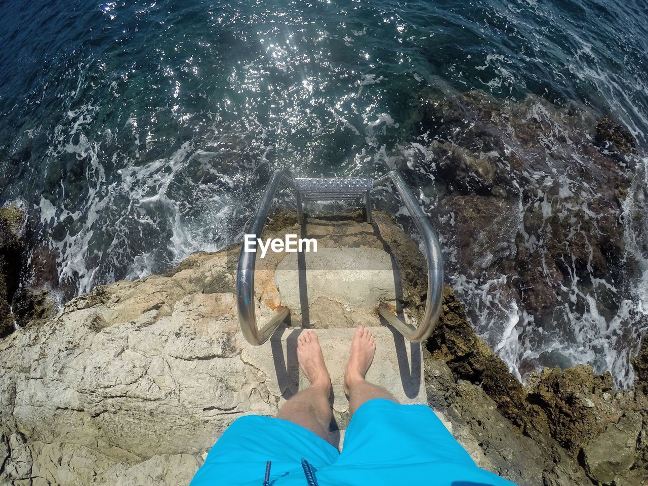 Low section of man standing by sea