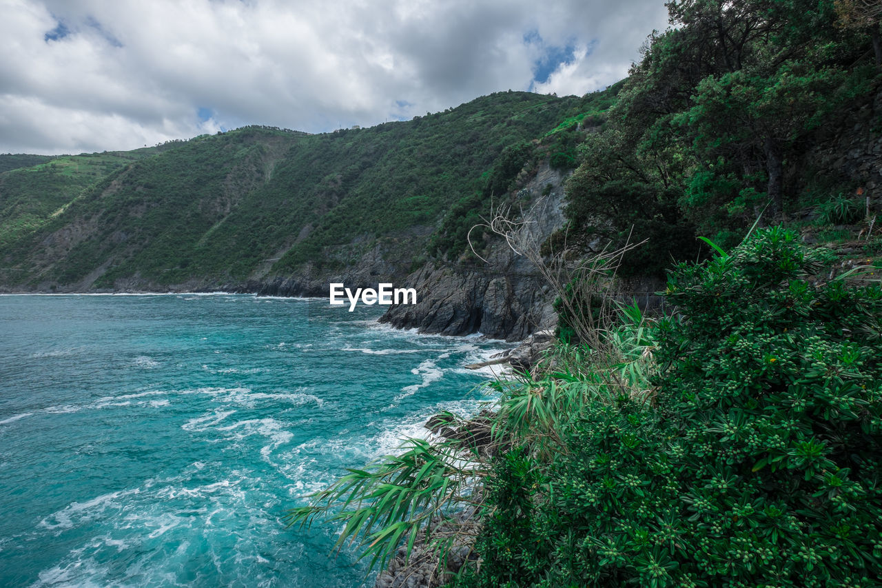 Scenic view of sea and mountains against sky