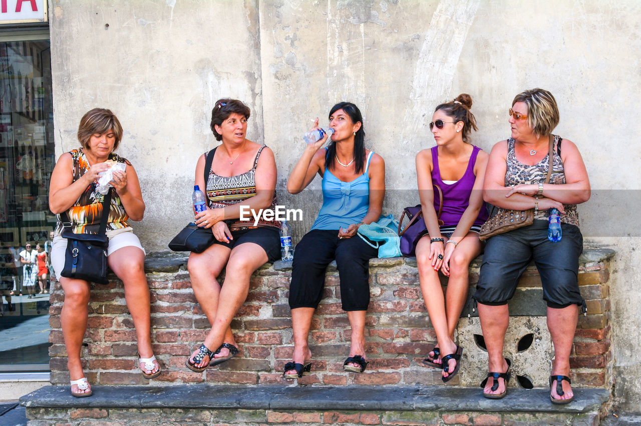 HIGH ANGLE VIEW OF FRIENDS STANDING ON THE FLOOR