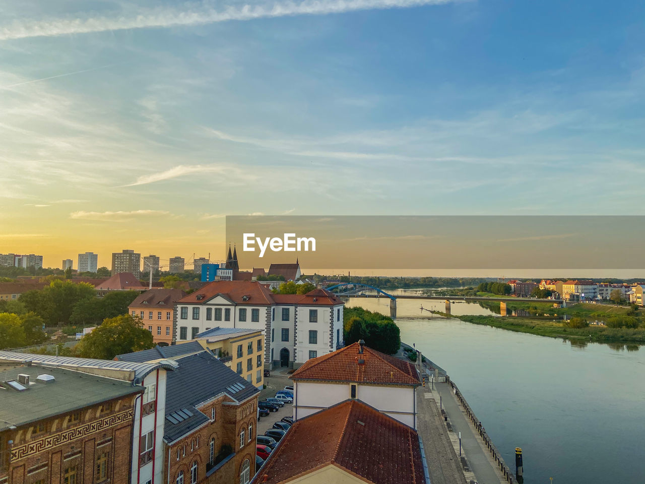 High angle view of buildings by river against sky