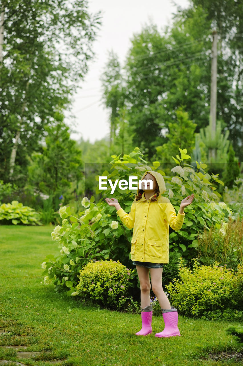 FULL LENGTH OF A GIRL STANDING ON PLANTS