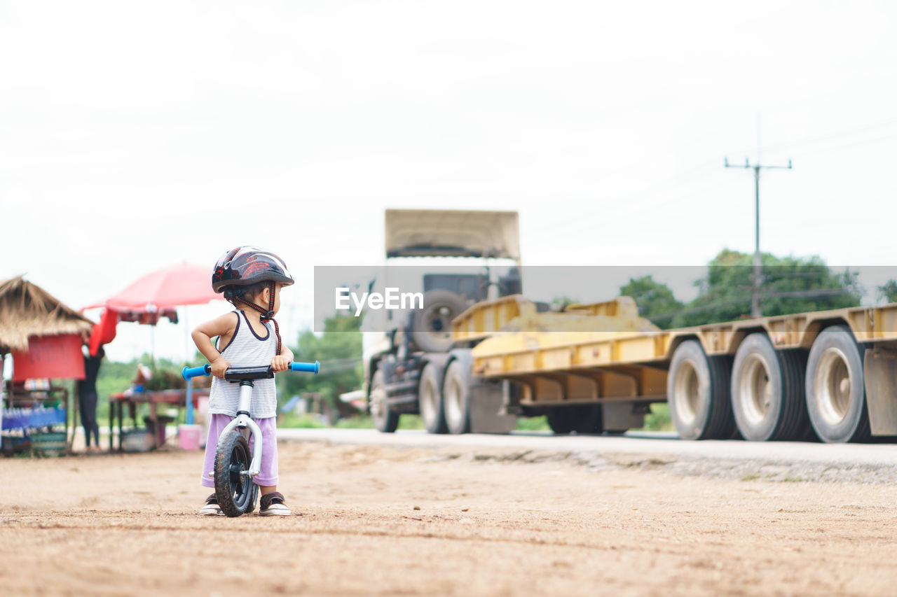 Full length of boy with bicycle at roadside