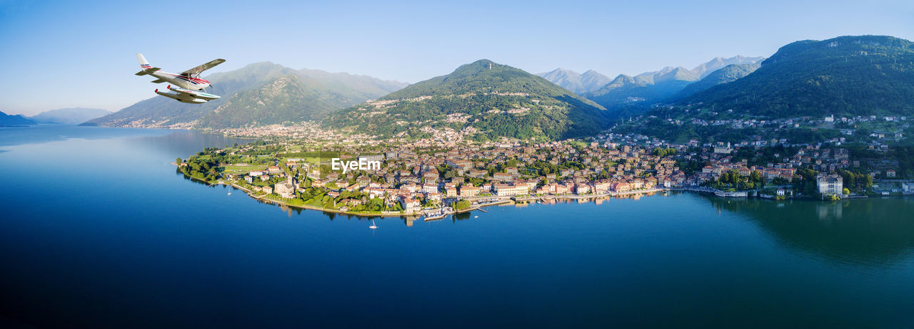 Airplane over lake towards town