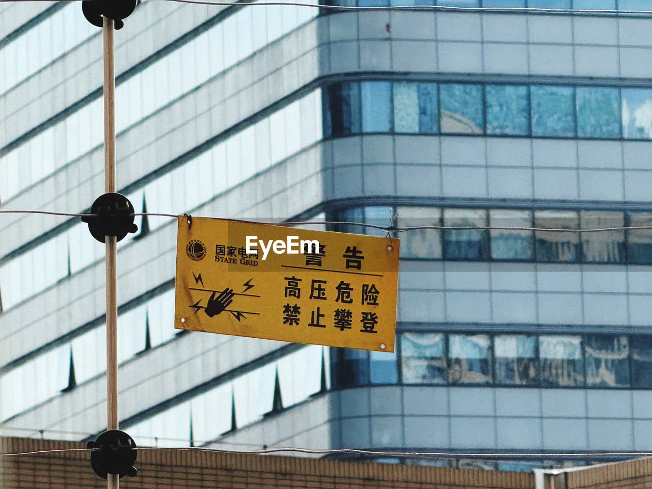architecture, building exterior, built structure, sign, city, communication, building, text, office building exterior, guidance, facade, no people, office, road sign, urban area, glass, day, downtown, western script, low angle view, outdoors, reflection, directional sign, wall, blue, information sign, window, city life