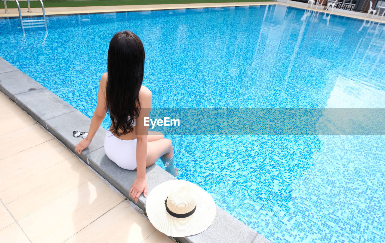 High angle view of seductive woman sitting by pool