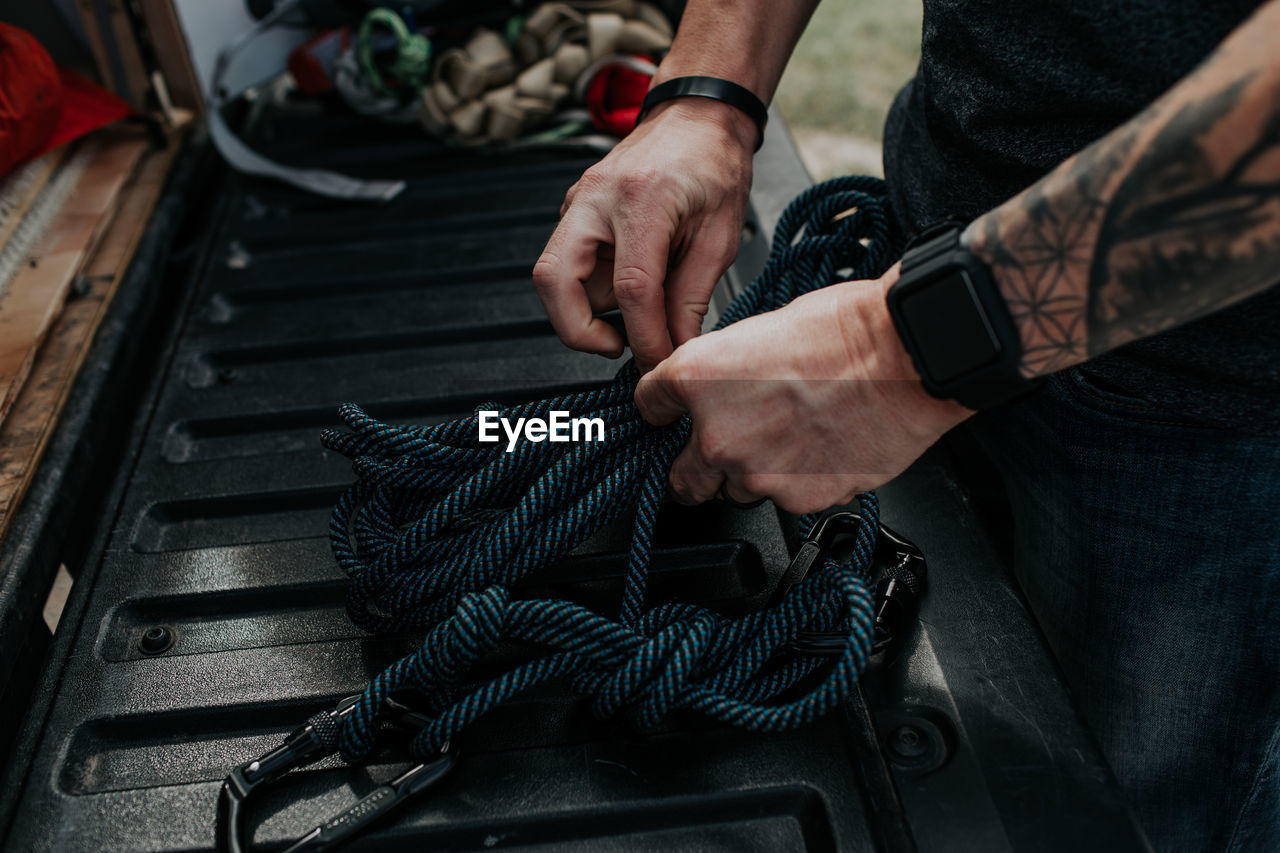 Close up of man prepping climbing ropes