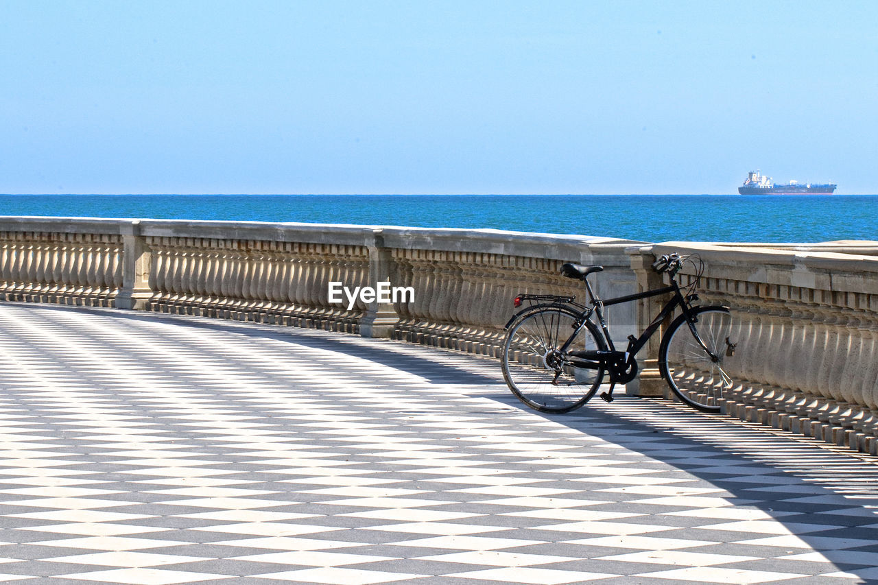 BICYCLE BY RAILING AGAINST SEA