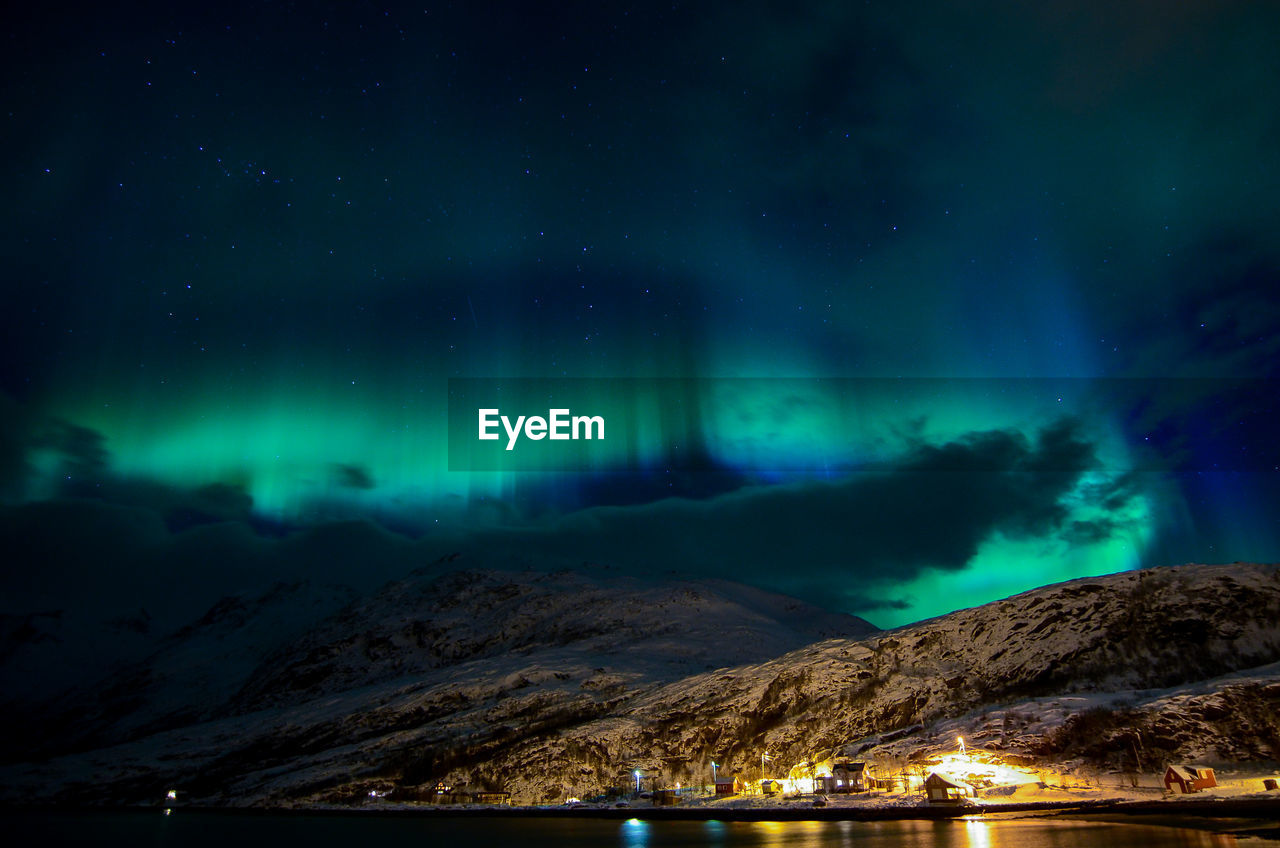 Scenic view of illuminated mountains against sky at night