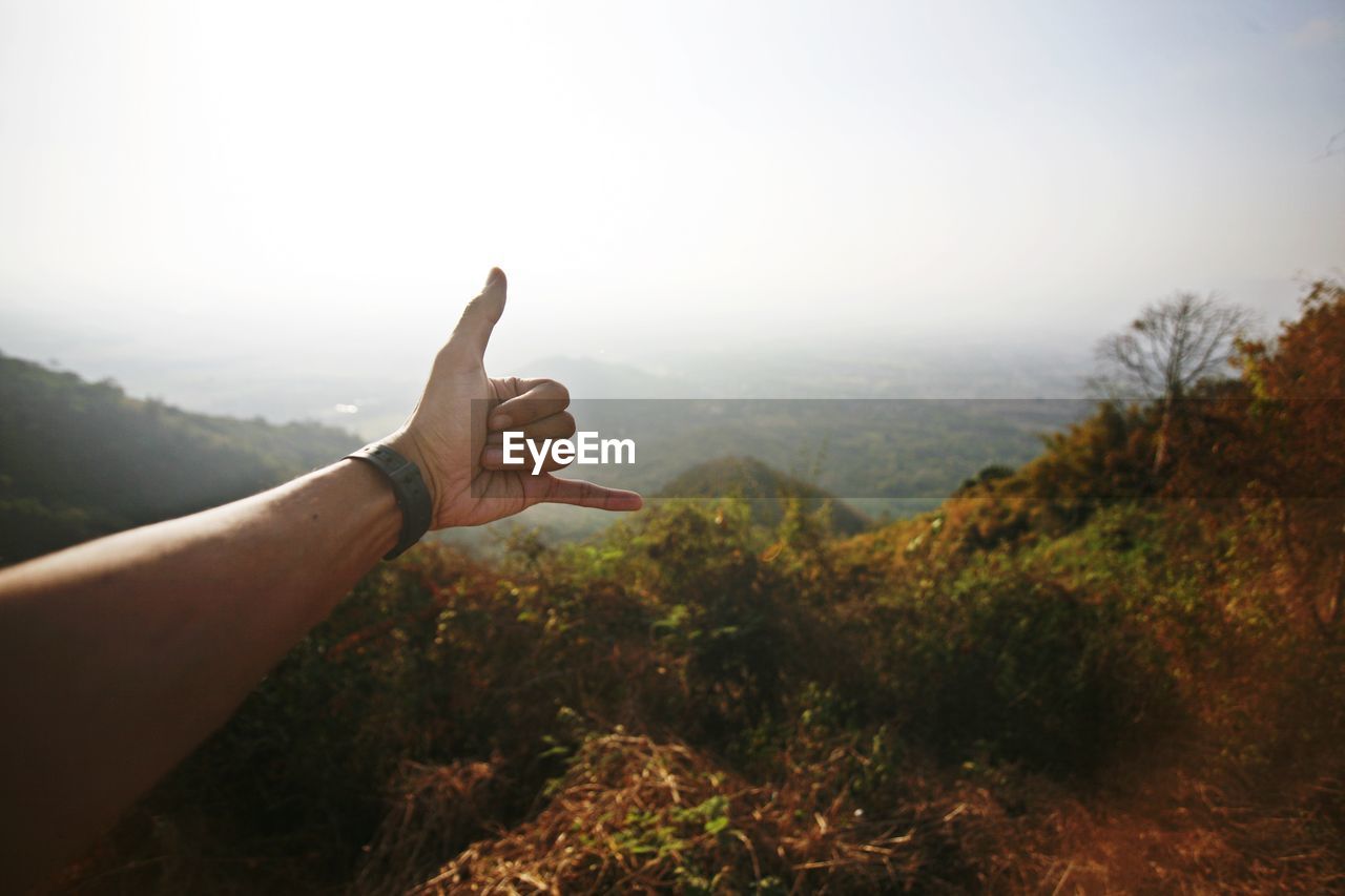 Midsection of person on mountain against sky