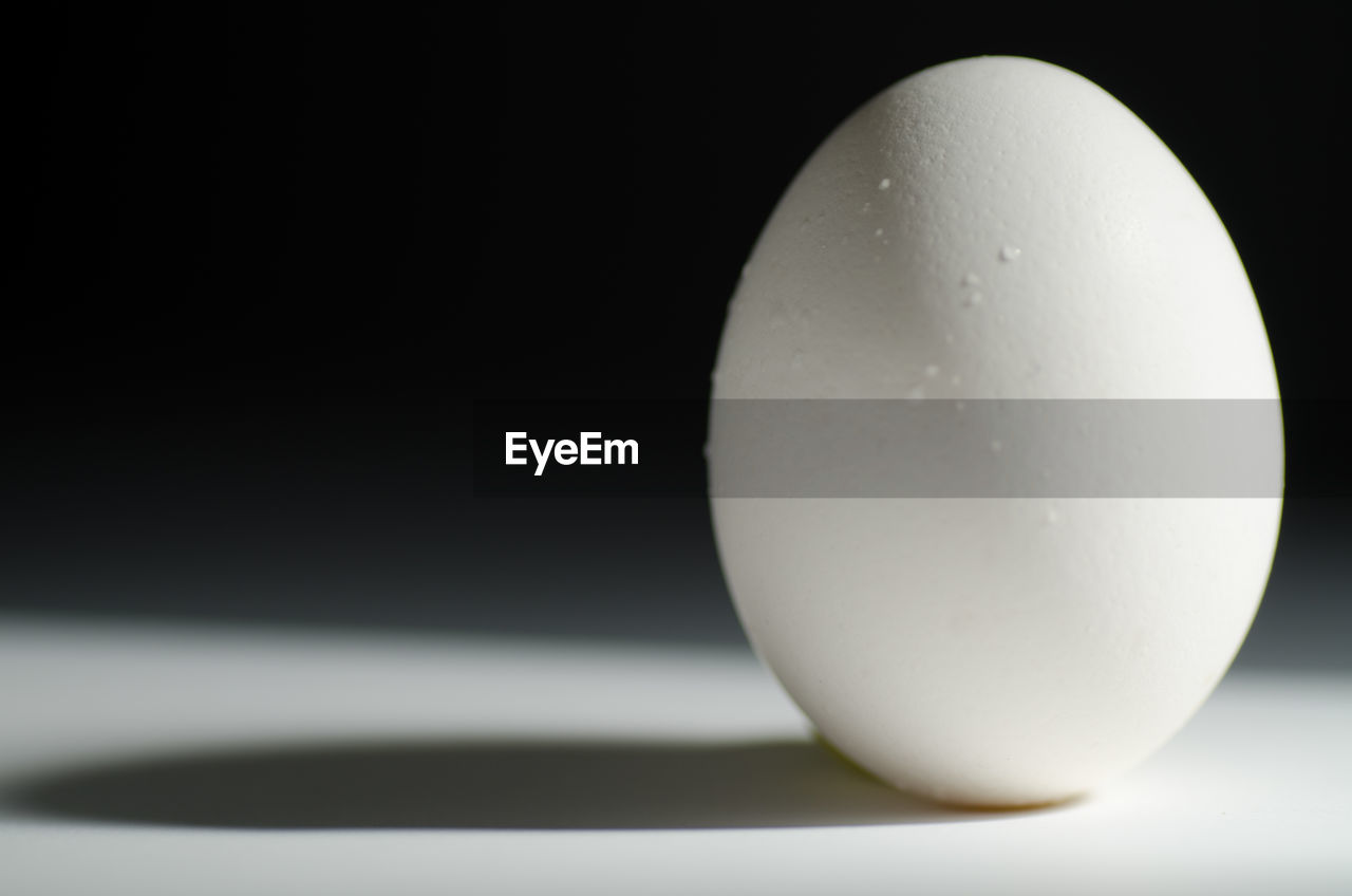 Close-up of egg on table against black background
