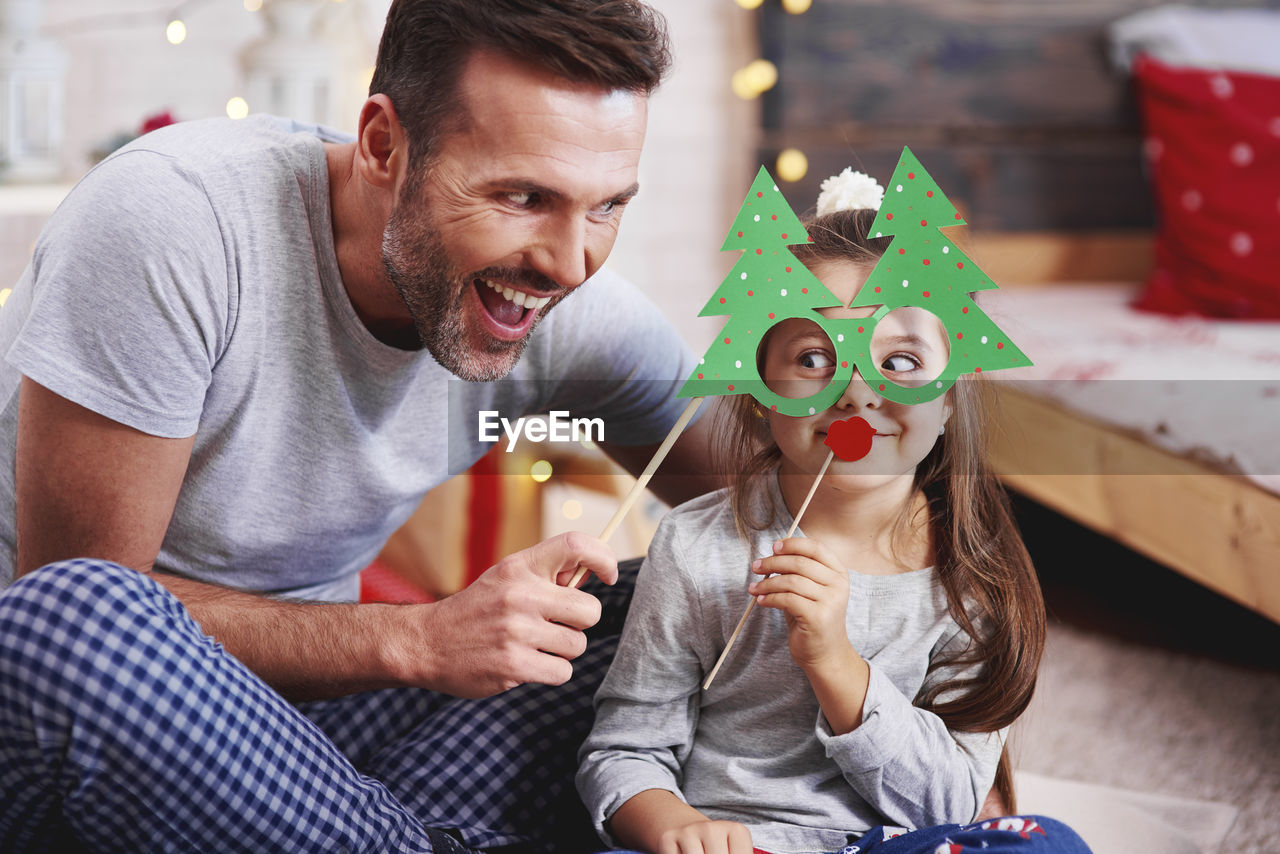 Happy father and daughter with props at home during christmas