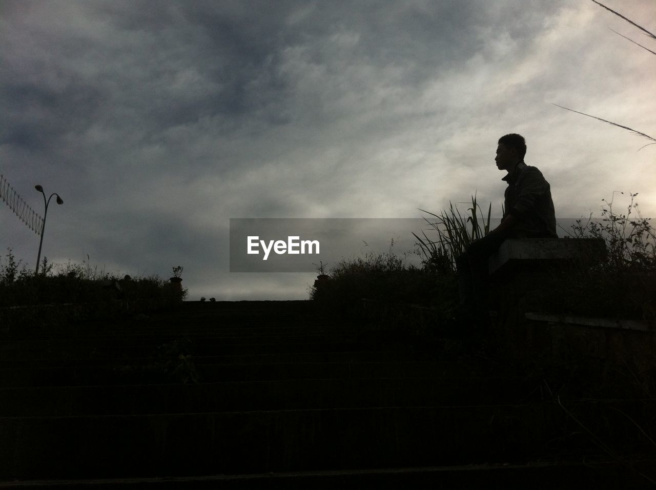 SILHOUETTE OF WOMAN SITTING AGAINST SKY