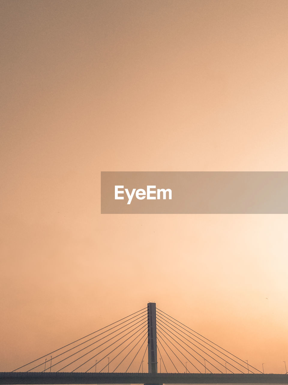 Low angle view of suspension bridge against sky during sunset