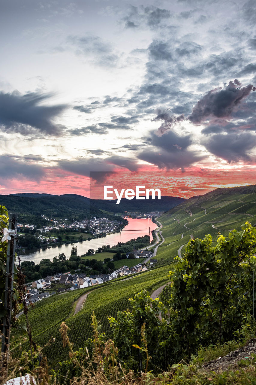 High angle view of townscape and river against sky with beautiful sunset