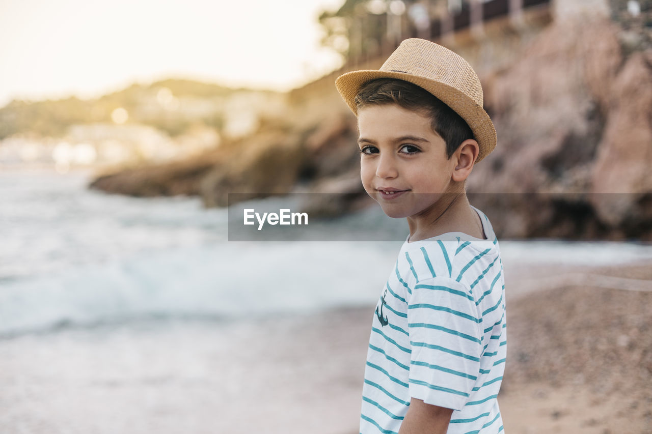 Portrait of smiling boy standing on beach