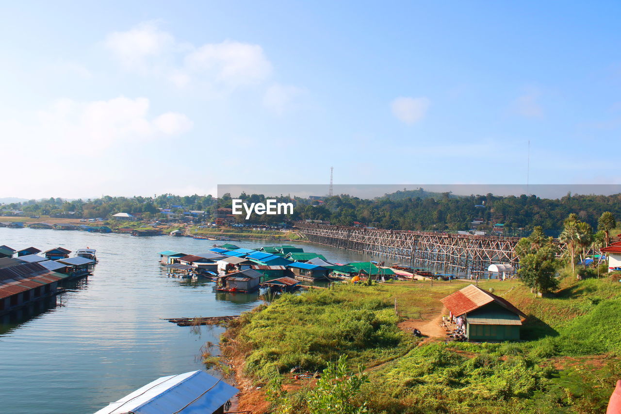 High angle view of houses by river against sky