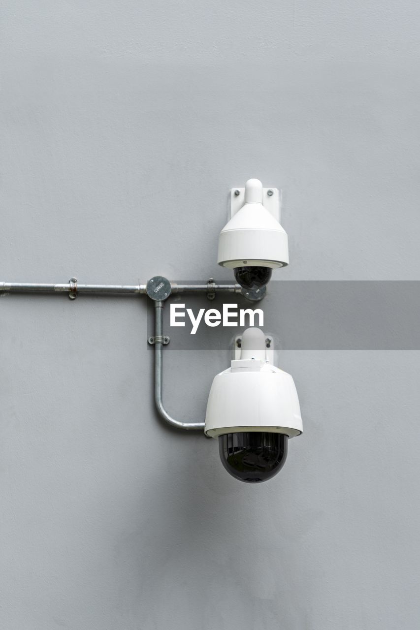 Close-up of security cameras mounted on wall