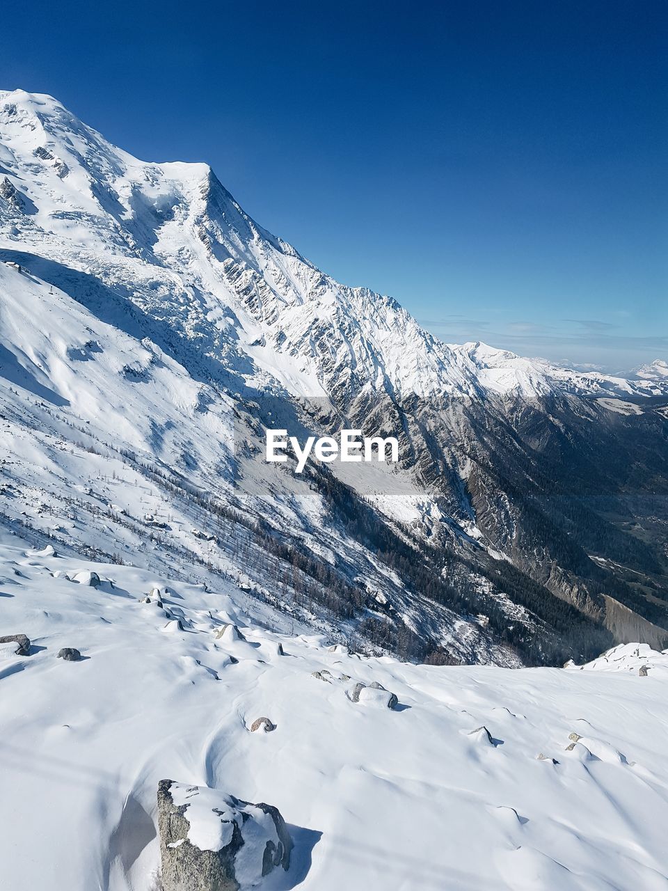 Scenic view of snowcapped mountains against blue sky