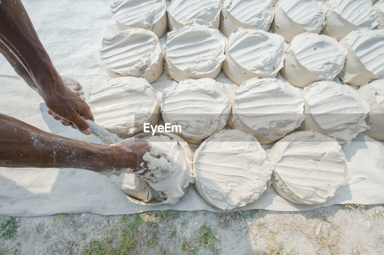 Cropped hands of man filling dough in bowls