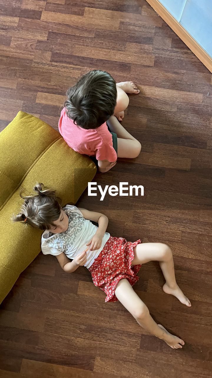 Siblings laying on the floor and watching tv