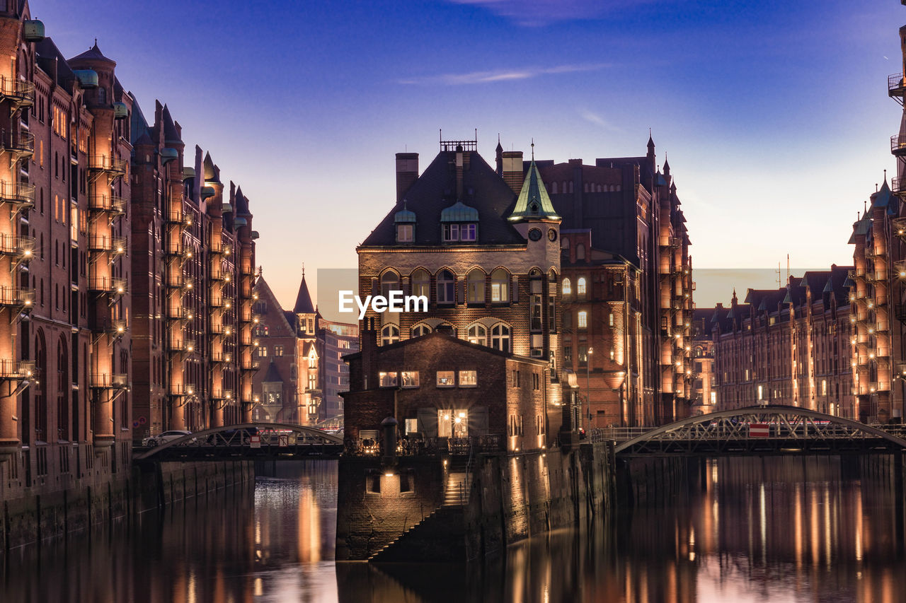 REFLECTION OF BUILDINGS IN CITY AT DUSK