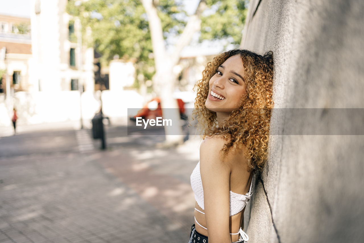 Portrait of smiling young woman in city