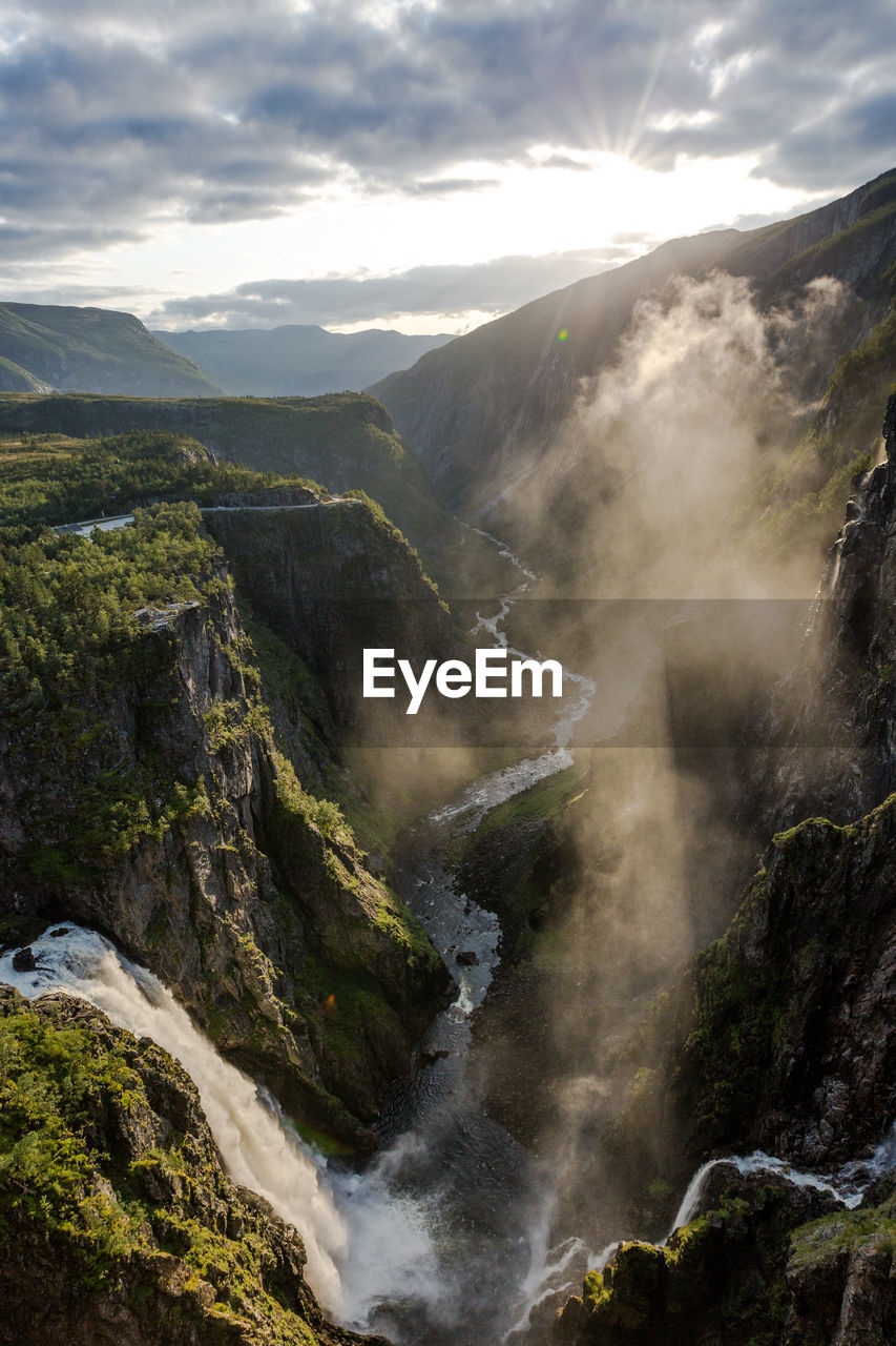 Scenic view of waterfall and mountains