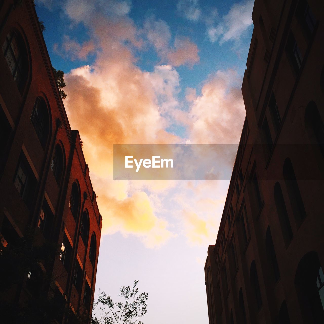 LOW ANGLE VIEW OF BUILDINGS AGAINST CLOUDY SKY