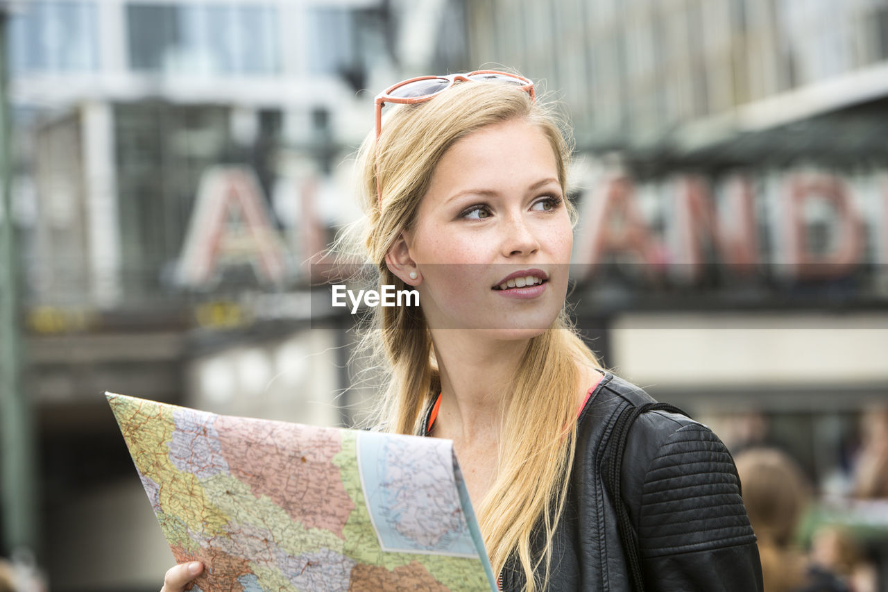 Woman holding map while looking away