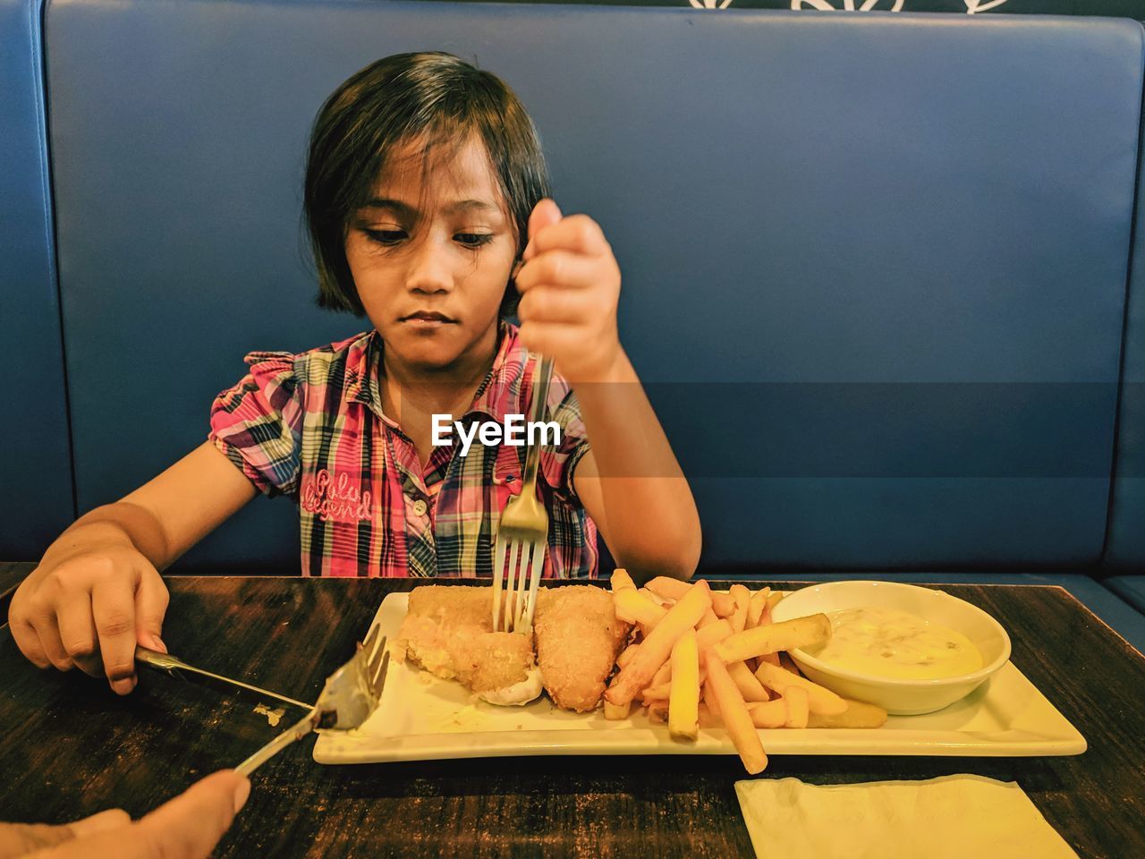 Girl having fish and chips in restaurant