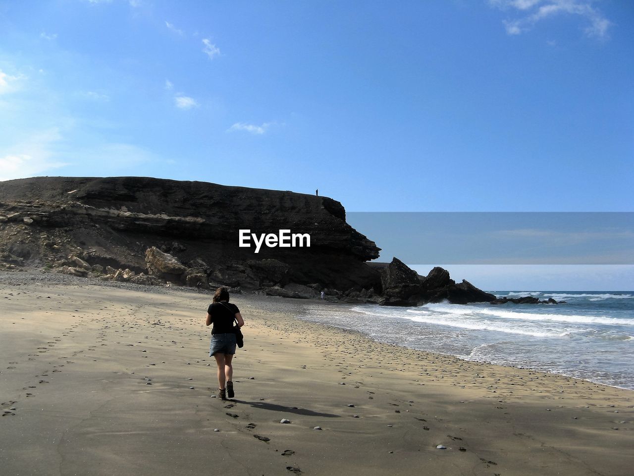 Rear view of woman walking on beach