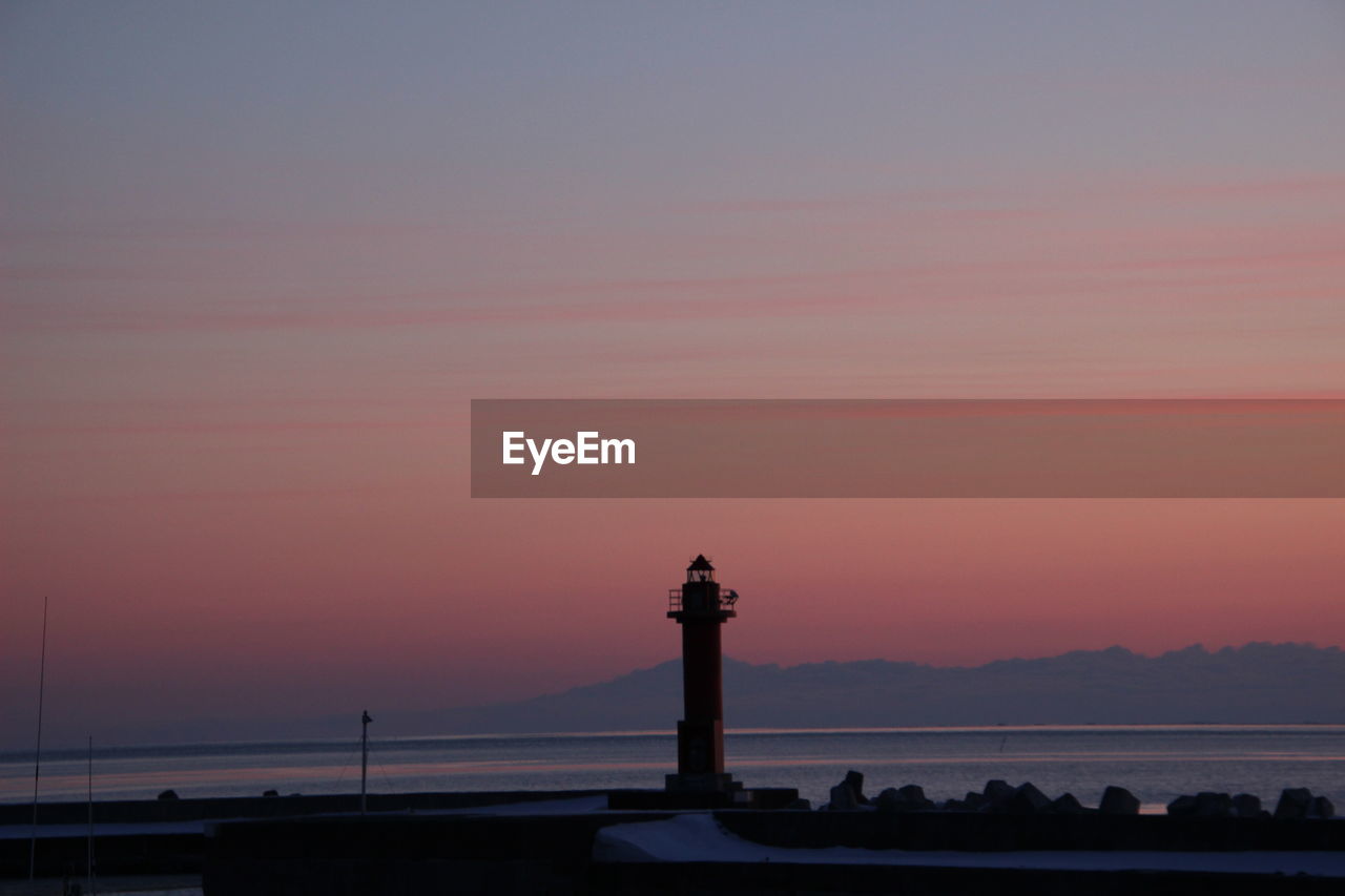 Silhouette of lighthouse against sky during sunset