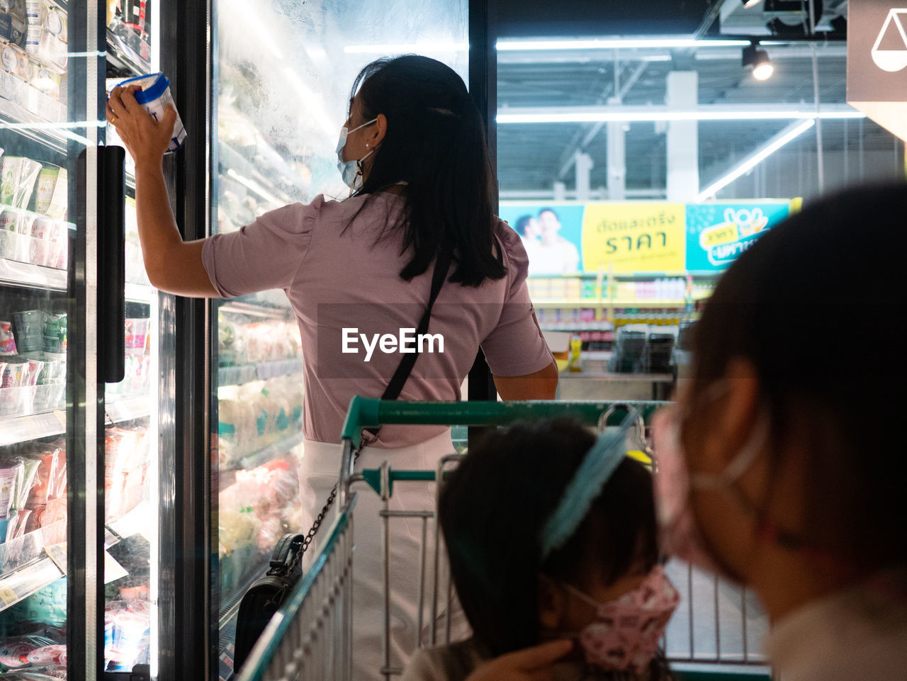 REAR VIEW OF A WOMAN LOOKING AT STORE