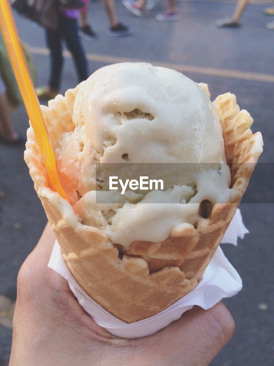 Cropped image of hand holding ice cream on street