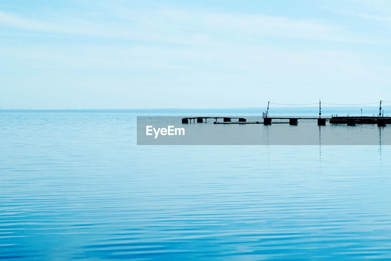 water, sky, sea, horizon, beauty in nature, tranquility, scenics - nature, tranquil scene, nature, horizon over water, waterfront, ocean, day, shore, blue, nautical vessel, no people, reflection, idyllic, transportation, bay, outdoors, non-urban scene, vehicle, rippled, mode of transportation, cloud, copy space, travel, wave, pier