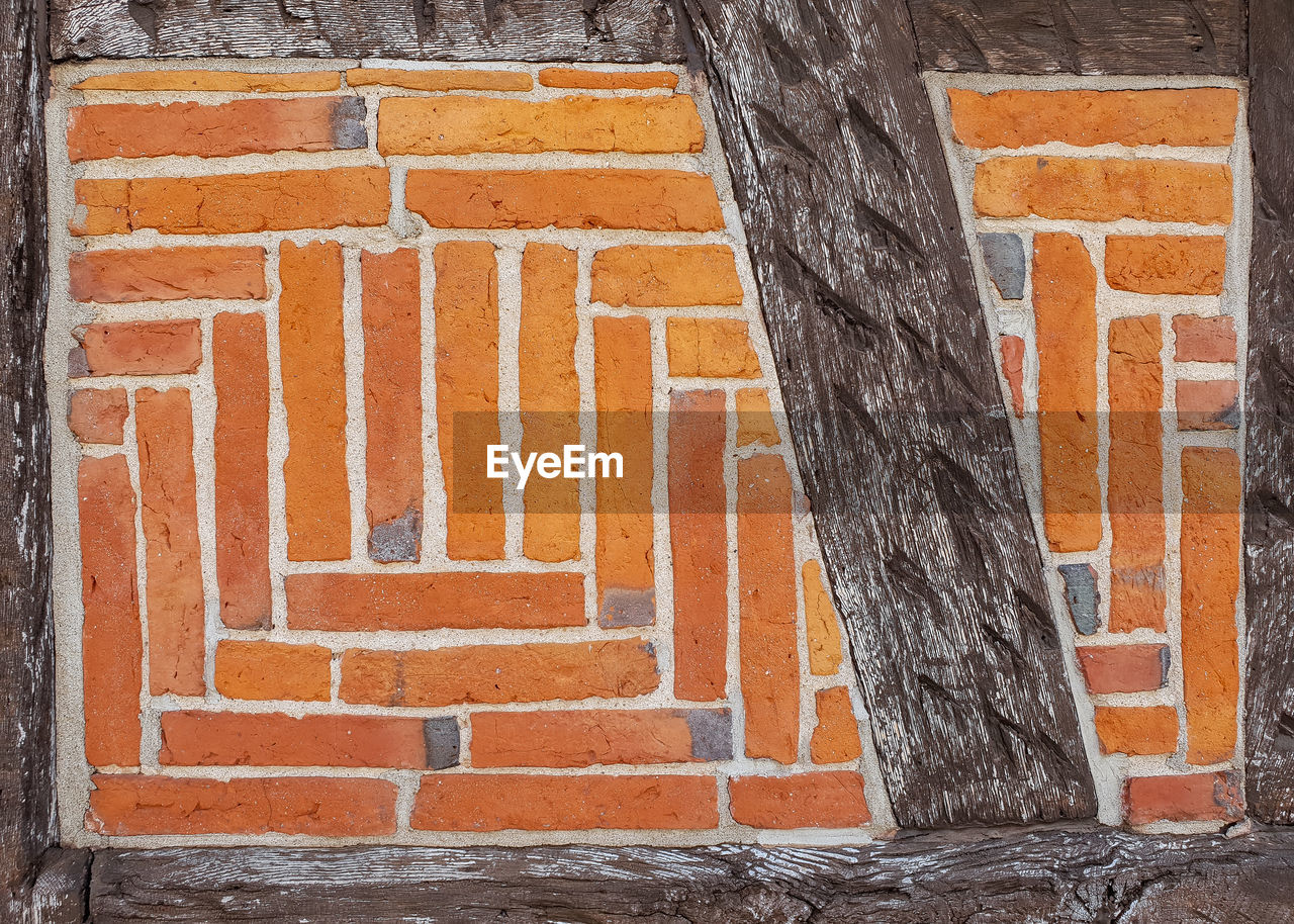 FULL FRAME SHOT OF BRICK WALL WITH BUILDING