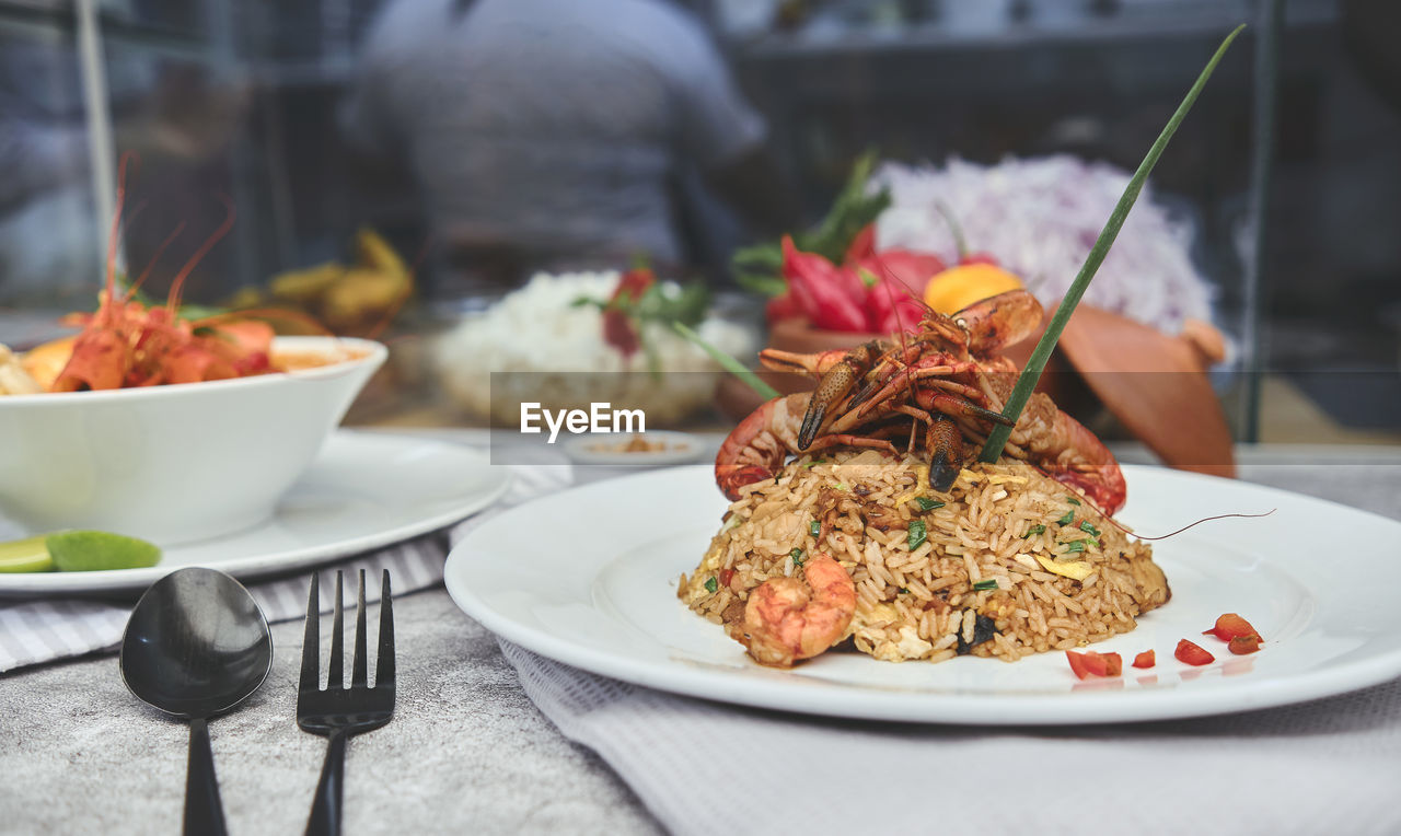 Peruvian food, called arroz chaufa with seafood and chupe de camarones prawns soup. top view