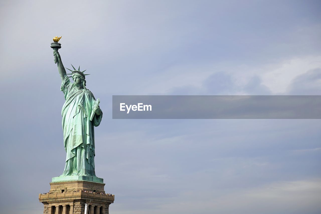 Statue of liberty against cloudy sky