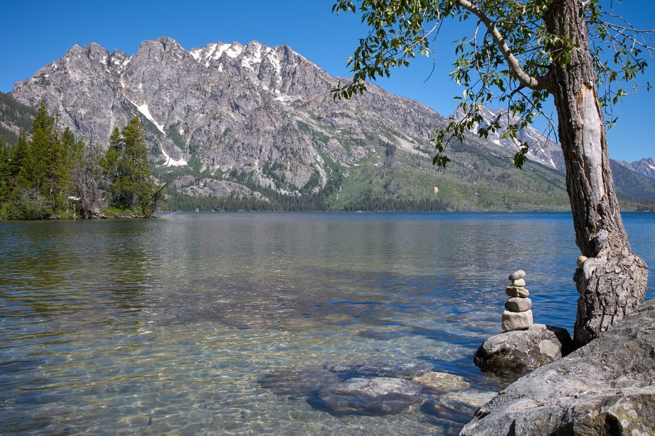 Scenic view of lake and mountains against clear sky