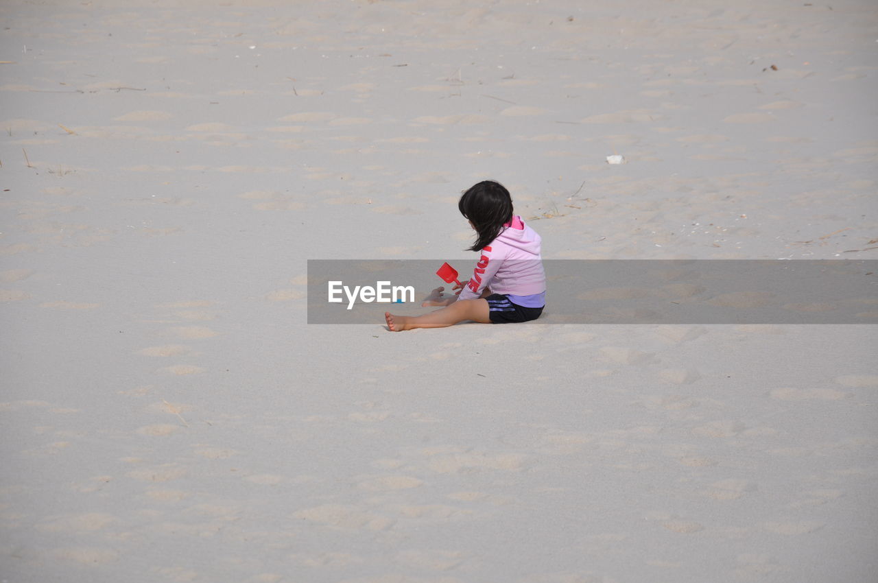 Side view of girl playing on beach