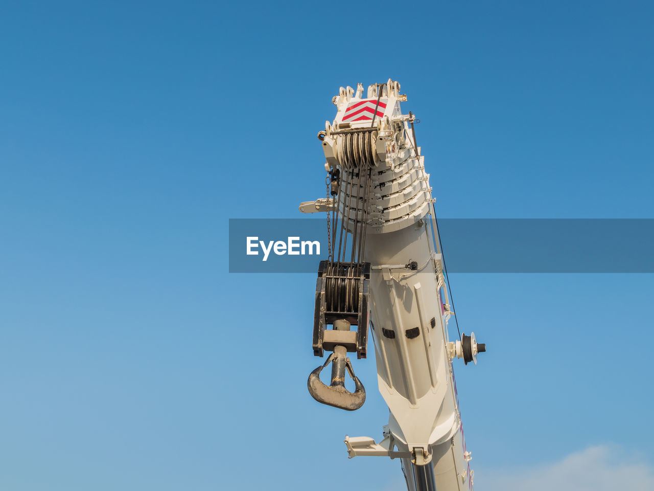 Low angle view of crane against clear blue sky