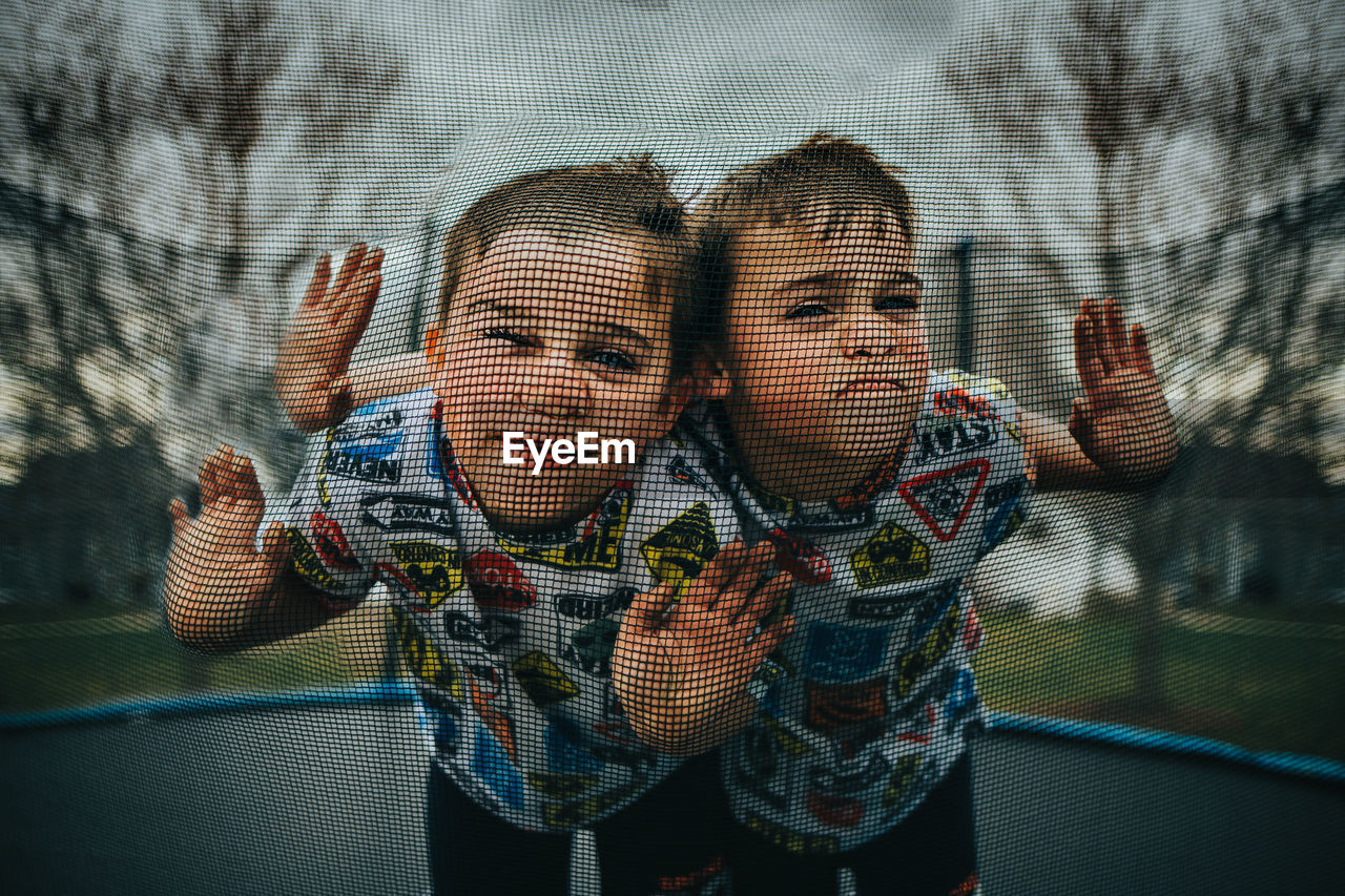 Twin boys being silly on trampoline