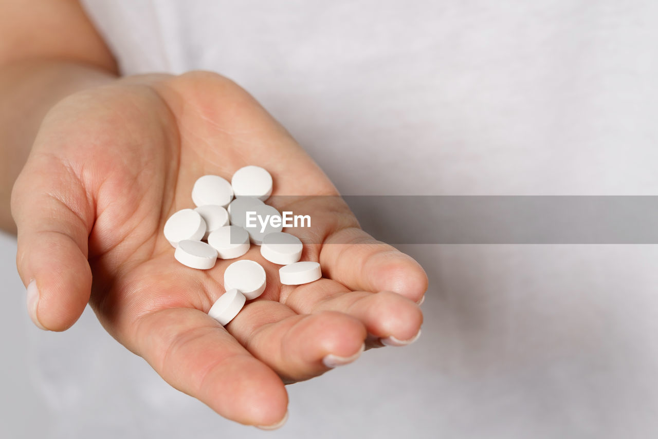 cropped hand of woman holding pills