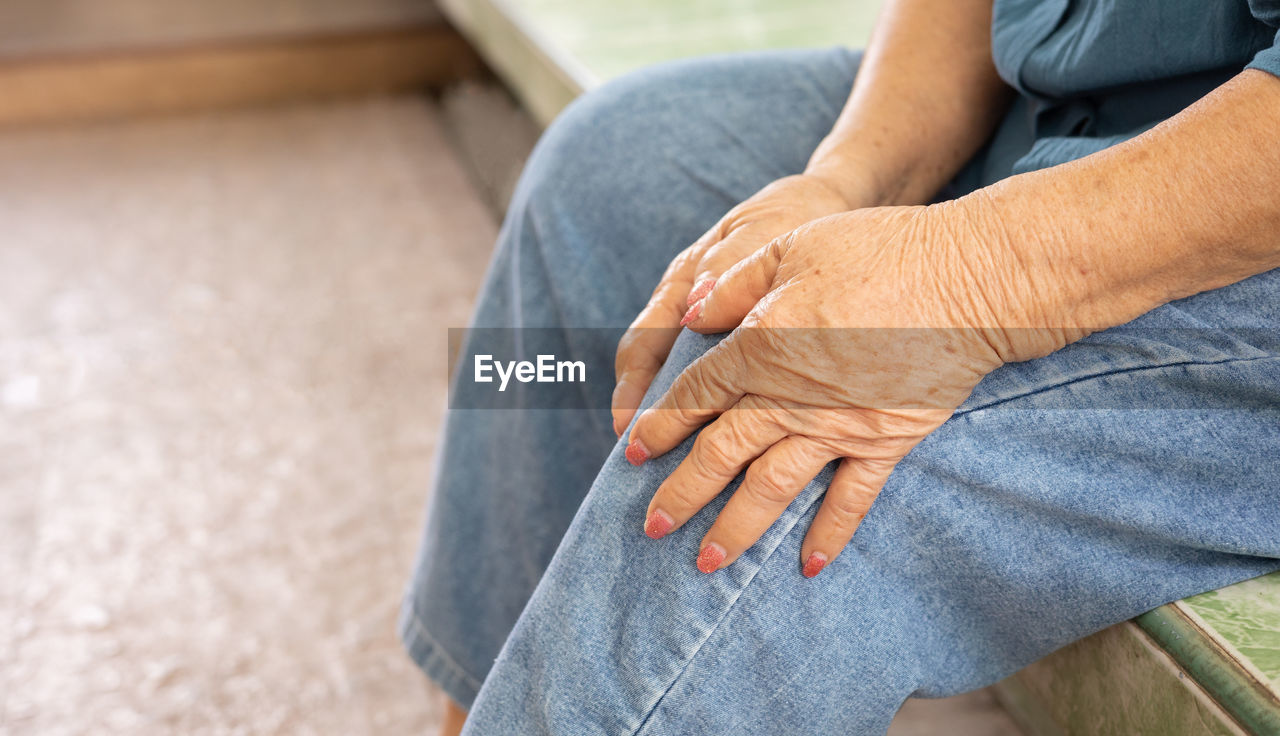 MIDSECTION OF WOMAN SITTING ON FLOOR