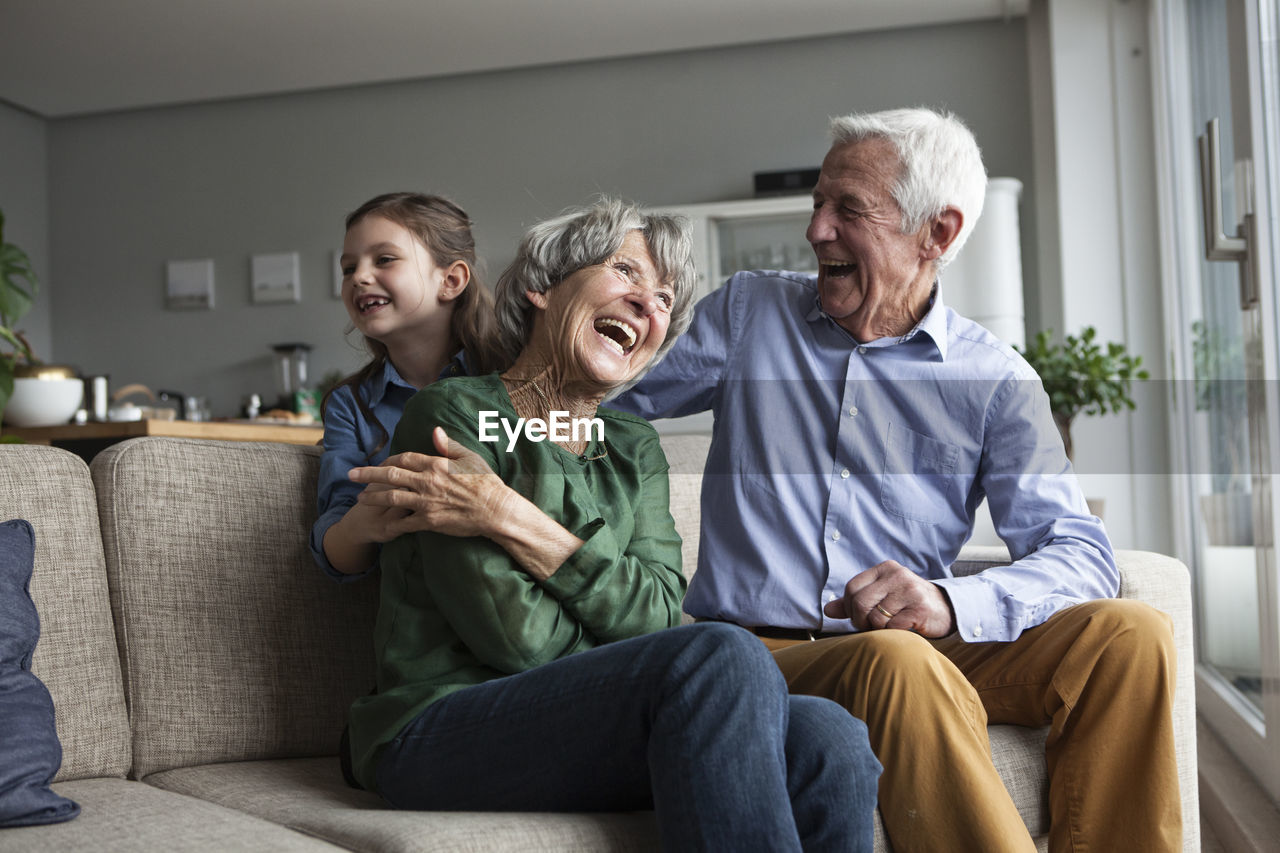 Little girl and her grandparents having fun at home