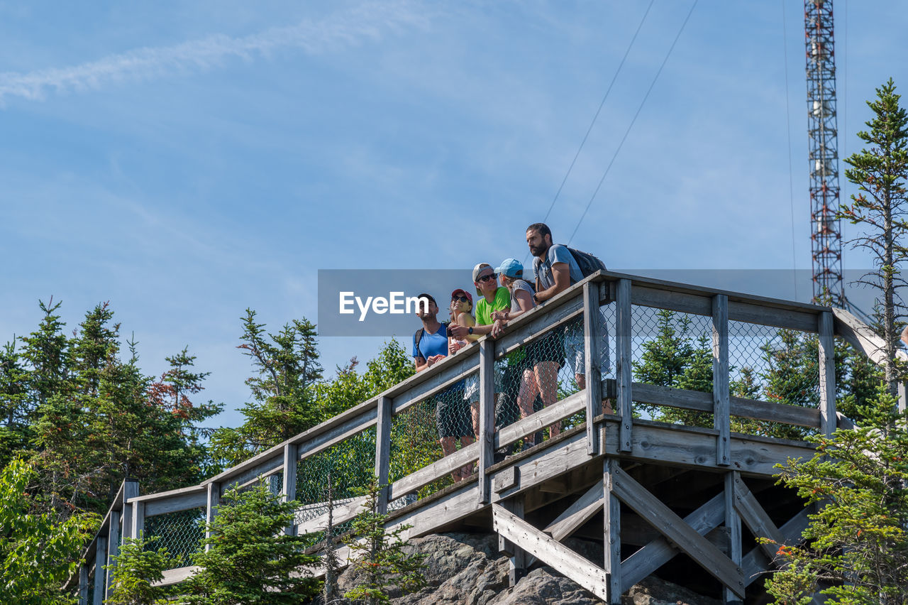 LOW ANGLE VIEW OF PEOPLE ON FOOTBRIDGE