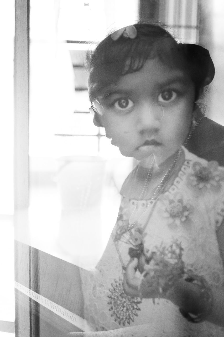 Portrait of girl seen through glass with reflection