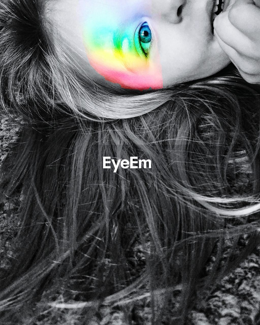 Digital composite image of girl with rainbow color flash on face