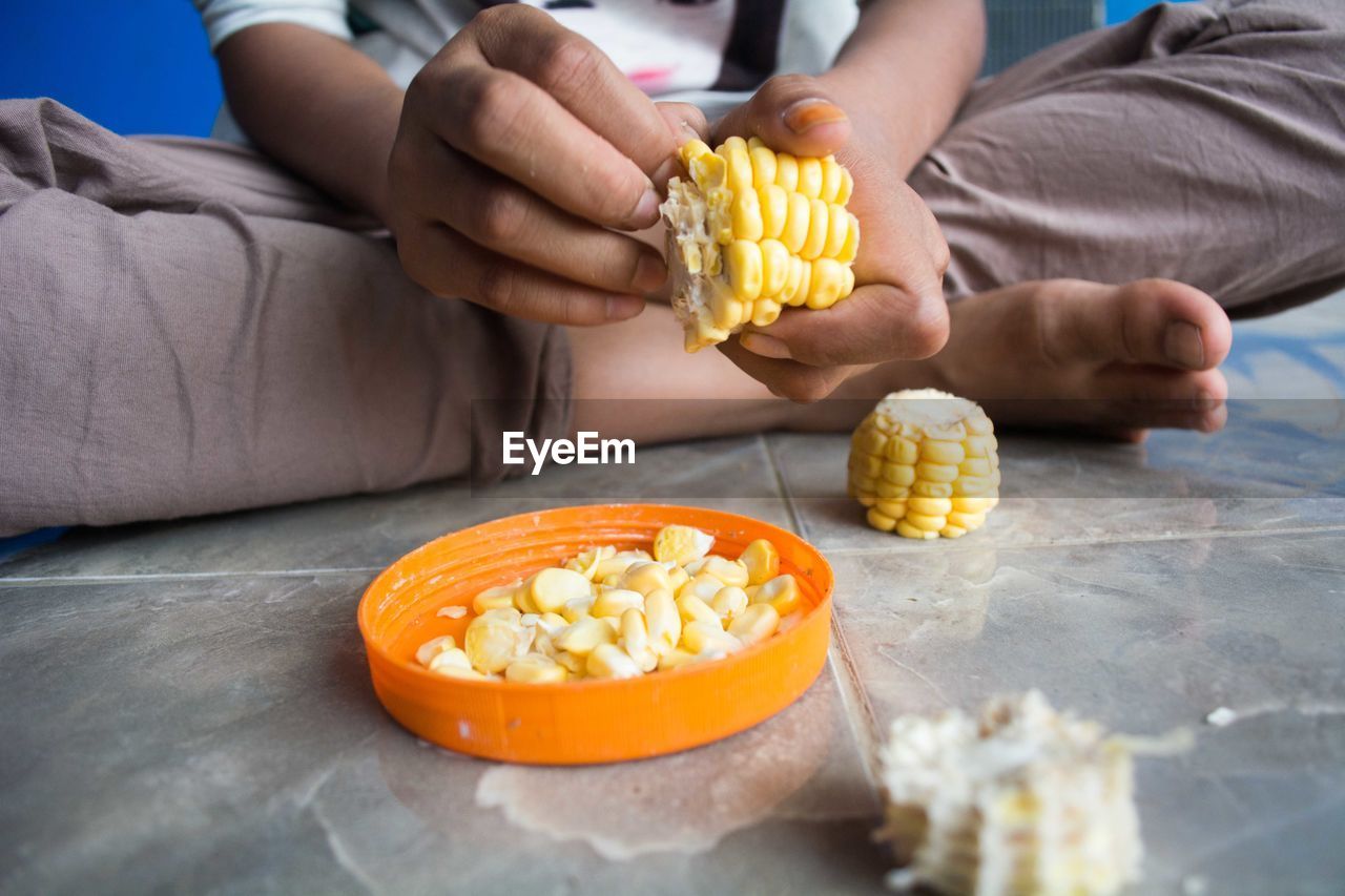 MIDSECTION OF MAN HOLDING FOOD