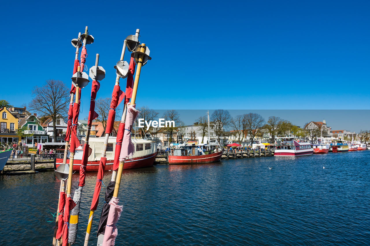 Ship moored at harbor against clear blue sky